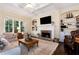 Living room with a stone fireplace, custom built-ins, hardwood floors, and natural light at 6335 Hampton Creek Dr, Cumming, GA 30041