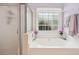 Elegant bathroom featuring a soaking tub with decorative window and separate glass shower at 810 Abbotts Mill Ct # 83, Duluth, GA 30097