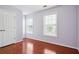 Bedroom with hardwood floors, closet, and natural light from two windows at 810 Abbotts Mill Ct # 83, Duluth, GA 30097