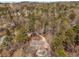 An aerial view shows a home nestled among mature trees with a pool and circular driveway at 9835 Trace Vly, Sandy Springs, GA 30350
