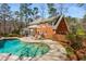 The spacious backyard has a freeform pool, a patio, and beautiful landscaping at 9835 Trace Vly, Sandy Springs, GA 30350