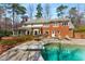 The large backyard includes a pool, patio, and deck with outdoor grill, all nestled amongst mature trees at 9835 Trace Vly, Sandy Springs, GA 30350