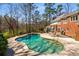 A beautiful backyard features a freeform pool, patio, and mature trees providing shade and privacy at 9835 Trace Vly, Sandy Springs, GA 30350
