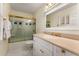 Bright bathroom featuring white vanity with gold hardware and a tub with a glass enclosure at 9835 Trace Vly, Sandy Springs, GA 30350