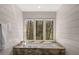 Luxurious bathroom showcasing a marble-encased tub with a window offering a view of the surrounding trees at 9835 Trace Vly, Sandy Springs, GA 30350