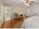 A cozy bedroom features wood floors, a ceiling fan and a view into the bright ensuite bathroom at 9835 Trace Vly, Sandy Springs, GA 30350