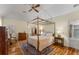 This bedroom features a four-poster bed, wood floors, ceiling fan and a doorway into the ensuite bathroom at 9835 Trace Vly, Sandy Springs, GA 30350