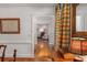 View from dining room through doorways into adjoining rooms showcasing hardwood floors and plaid drapes at 9835 Trace Vly, Sandy Springs, GA 30350