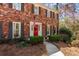 Charming brick home with a red front door, American flag, and manicured landscaping at 9835 Trace Vly, Sandy Springs, GA 30350