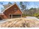 Angle shot of exterior brick elevation, multiple-car garage, and extended driveway at 9835 Trace Vly, Sandy Springs, GA 30350
