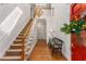 Elegant foyer with hardwood floors, a staircase, chandelier, and a red front door adorned with a floral arrangement at 9835 Trace Vly, Sandy Springs, GA 30350