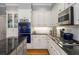 Kitchen features granite countertops, stainless steel appliances, white cabinets and a Viking blue stove at 9835 Trace Vly, Sandy Springs, GA 30350