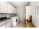 Functional laundry room with white cabinets, granite countertops, and modern washer and dryer at 9835 Trace Vly, Sandy Springs, GA 30350