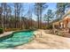 A freeform swimming pool with a handrail is set amongst a lush backdrop of mature trees at 9835 Trace Vly, Sandy Springs, GA 30350