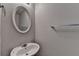 Small bathroom featuring white sink, oval mirror, and grey walls at 2892 Norfair Ne Loop, Lithonia, GA 30038