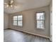 Bedroom with neutral walls, two large windows, ceiling fan, and gray-toned wood flooring at 2892 Norfair Ne Loop, Lithonia, GA 30038