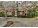 Charming red brick townhome featuring a well-manicured lawn and flowering trees at 2892 Norfair Ne Loop, Lithonia, GA 30038