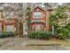 Charming red brick townhome featuring a well-manicured lawn and flowering trees at 2892 Norfair Ne Loop, Lithonia, GA 30038