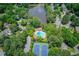 Aerial view of the neighborhood, showcasing a lake, pool, and tennis courts surrounded by lush greenery at 363 Wilcrest Dr, Lawrenceville, GA 30044