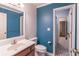 Bathroom featuring a vanity, toilet, and a striking blue accent wall that adds character and style to the space at 363 Wilcrest Dr, Lawrenceville, GA 30044