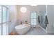 A stylish bathroom showcases a modern soaking tub, pendant light, and shuttered windows at 363 Wilcrest Dr, Lawrenceville, GA 30044