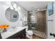 Bathroom featuring a dark vanity, decorative mirror, and updated shower with mosaic tile at 1125 Francis Ne St, Brookhaven, GA 30319
