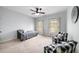 This bedroom has a ceiling fan, two windows, and a seating area with plaid chairs at 1125 Francis Ne St, Brookhaven, GA 30319