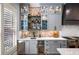 Kitchen boasts a wet bar, wine fridge, and stainless appliances, complemented by gray cabinets and a brick backsplash at 1125 Francis Ne St, Brookhaven, GA 30319