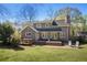 Back exterior view of the home featuring a wood patio, lounge set, and luscious landscaping at 235 Chicopee Ne Dr, Marietta, GA 30060