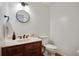 Half bathroom with dark wood vanity, marble countertop, and round mirror at 235 Chicopee Ne Dr, Marietta, GA 30060