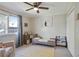 Bright bedroom featuring a large window, ceiling fan, light gray walls, and neutral carpet at 235 Chicopee Ne Dr, Marietta, GA 30060