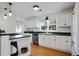 Well-lit kitchen with white cabinetry, stainless steel dishwasher, and dark countertops at 235 Chicopee Ne Dr, Marietta, GA 30060