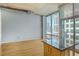 Sunlit living room boasting hardwood floors, concrete ceiling, and floor-to-ceiling windows with city views at 943 Peachtree Ne St # 1003, Atlanta, GA 30309