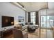 Inviting living room with a comfortable sectional sofa, floor-to-ceiling windows, and modern décor at 943 Peachtree Ne St # 1003, Atlanta, GA 30309