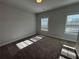 Bright bedroom featuring neutral walls, carpet floors, and natural light from two windows at 122 Stonehouse Dr, Cumming, GA 30040