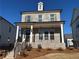 Two-story brick home with a covered front porch, detailed stairs, and a landscaped yard at 122 Stonehouse Dr, Cumming, GA 30040
