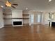 Bright open-concept living room with hardwood floors, fireplace, and kitchen in the background at 122 Stonehouse Dr, Cumming, GA 30040