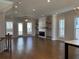 Bright open-concept living room with hardwood floors, fireplace, and abundant natural light from large windows at 122 Stonehouse Dr, Cumming, GA 30040