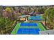 Aerial view highlighting community tennis courts and pool amidst a leafy residential area at 3149 Hidden Falls Ne Dr, Buford, GA 30519