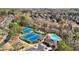 Aerial view of community tennis courts and swimming pool nestled among lush trees and homes at 3149 Hidden Falls Ne Dr, Buford, GA 30519