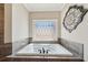 A soaking tub sits beneath a decorative window, providing a relaxing focal point in the bathroom at 3149 Hidden Falls Ne Dr, Buford, GA 30519