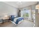 Bedroom featuring soft carpet, tray ceiling, decorative lighting and a serene window view at 3149 Hidden Falls Ne Dr, Buford, GA 30519