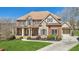 Beautiful two-story brick home with manicured lawn, stone accents, and charming front porch at 3149 Hidden Falls Ne Dr, Buford, GA 30519
