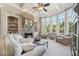 Cozy living room featuring a stone fireplace, built-in shelves, and a wall of windows at 3149 Hidden Falls Ne Dr, Buford, GA 30519