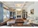 Bright living room featuring stone fireplace, built-in shelving, coffered ceilings, and ample natural light at 3149 Hidden Falls Ne Dr, Buford, GA 30519