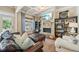 Comfortable living room featuring a stone fireplace, built-in shelves, and access to the outdoor pool area at 3149 Hidden Falls Ne Dr, Buford, GA 30519