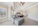 Spacious main bedroom with a tray ceiling, seating area, and windows overlooking the backyard at 3149 Hidden Falls Ne Dr, Buford, GA 30519