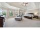 Spacious main bedroom with a tray ceiling, seating area, and windows overlooking the backyard at 3149 Hidden Falls Ne Dr, Buford, GA 30519