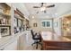 Office featuring a ceiling fan, a large wooden desk, and built-in shelving with a window offering natural light at 3149 Hidden Falls Ne Dr, Buford, GA 30519