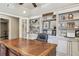 Office with a large wooden desk, built-in shelving with pictures, and a large leather office chair at 3149 Hidden Falls Ne Dr, Buford, GA 30519